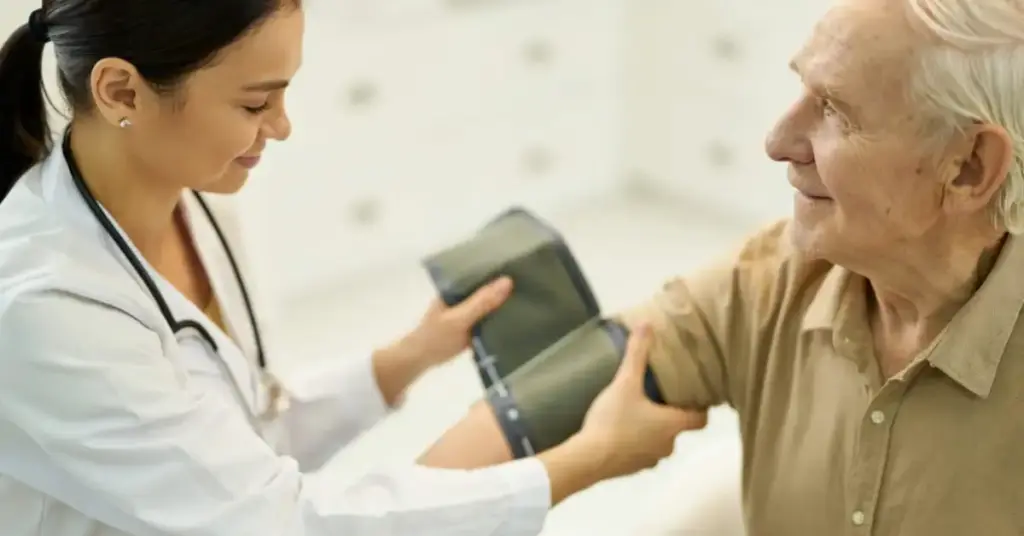 Jovem médica geriatra aferindo a pressão arterial de paciente idoso
