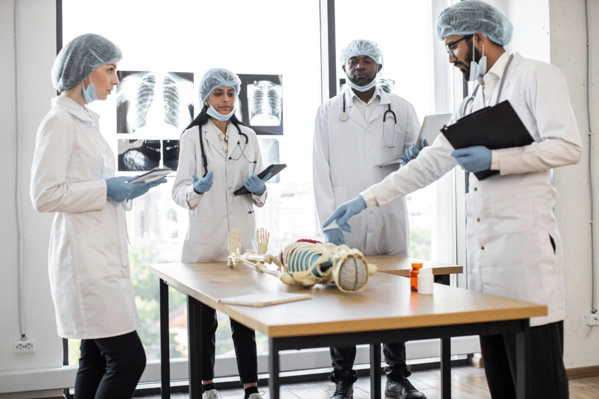 Grupo de jovens médicos analisando simulacro de esqueleto humano