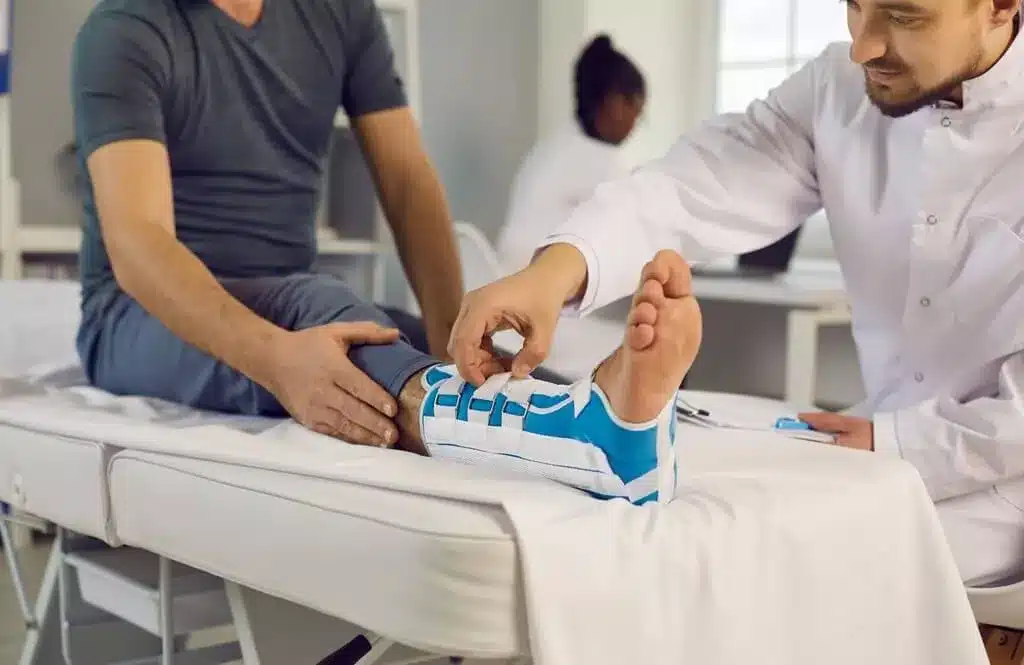 homem com pé machucado enfaixado em pronto-socorro