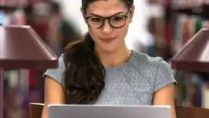 moça estudando com notebook em biblioteca